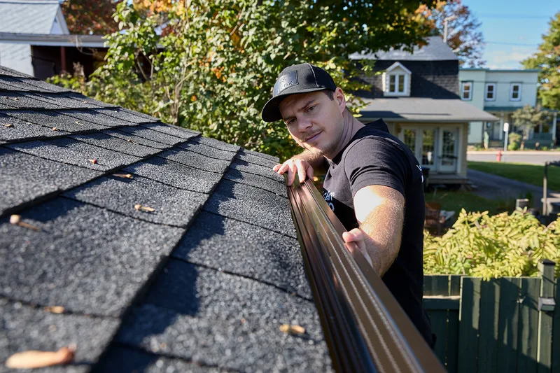 Installer inspecting the soffit and fascia at the roofline